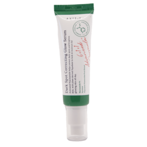 Dumsan A white and green tube labeled "Dark Spot Correcting Glow Serum" from the brand AXIS-Y. The tube features a red text signature and claims to reduce dark spots, promote even skin tone, and add a glow. It is capped with a white lid.