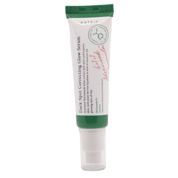 Dumsan Un tubo blanco y verde con la etiqueta "Dark Spot Correcting Glow Serum" de la marca AXIS-Y. El tubo tiene una firma de texto en rojo y afirma que reduce las manchas oscuras, promueve un tono de piel uniforme y agrega luminosidad. Tiene una tapa blanca.